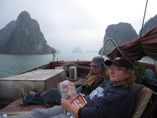 Emily on her journey reading on the boat in Halong Bay, Vietnam